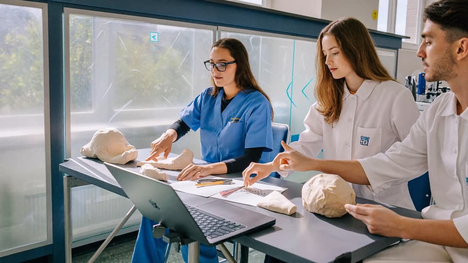 Trois jeunes étudiants en santé concentrés en salle de formation